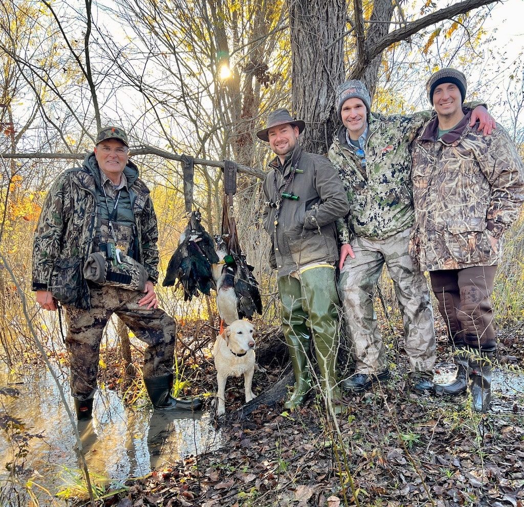 Duck hunters with their dog and catch after a successful hunt.