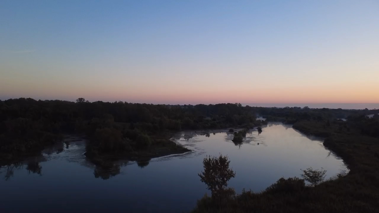 Scenic river landscape at dusk with a colorful horizon sky