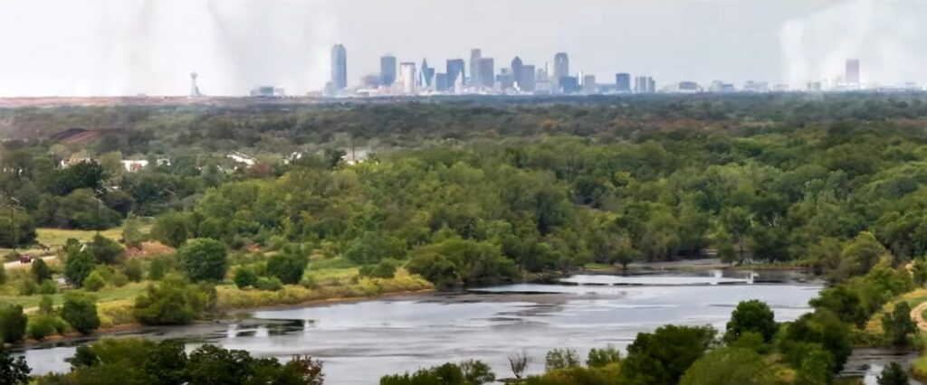 Aerial view of lush greenery with distant city skyline