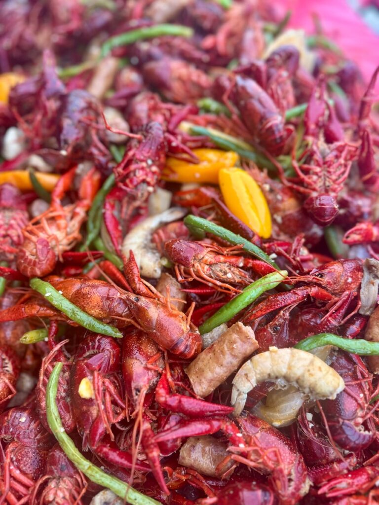 Crawfish boil with crawfish, sausage, green beans, peppers, shrimp, and onions.